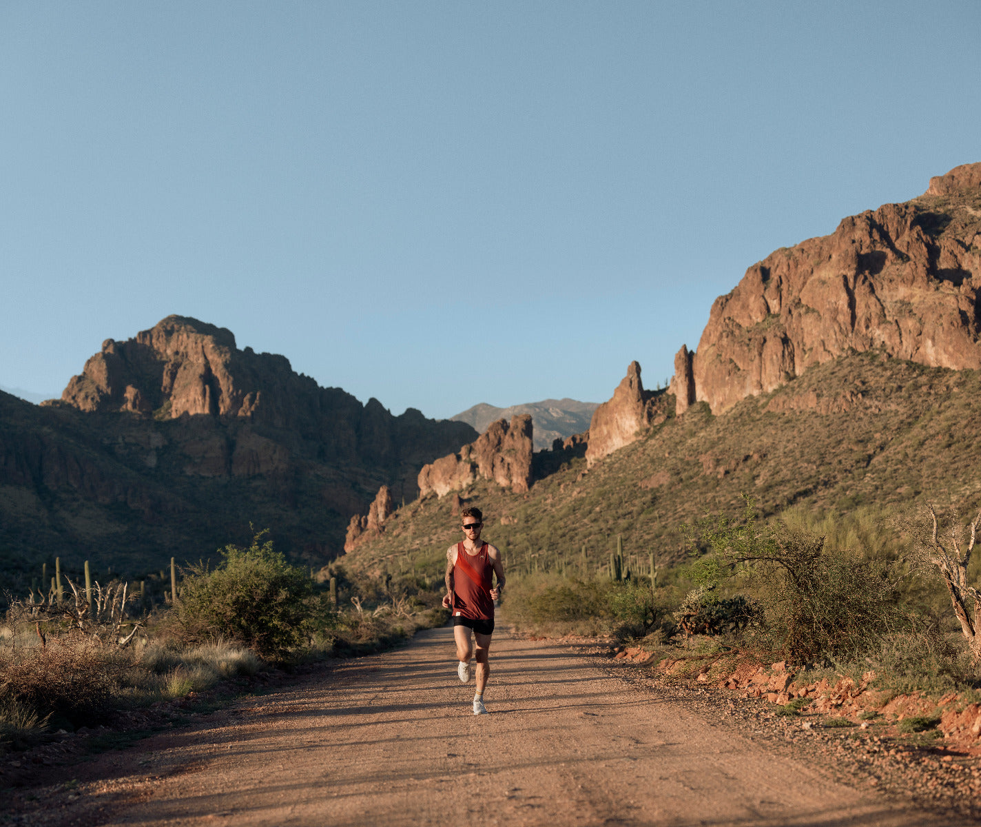 Garmin Forerunner 955 Solar Black smartwatch worn by a runner on a desert trail with rugged mountains