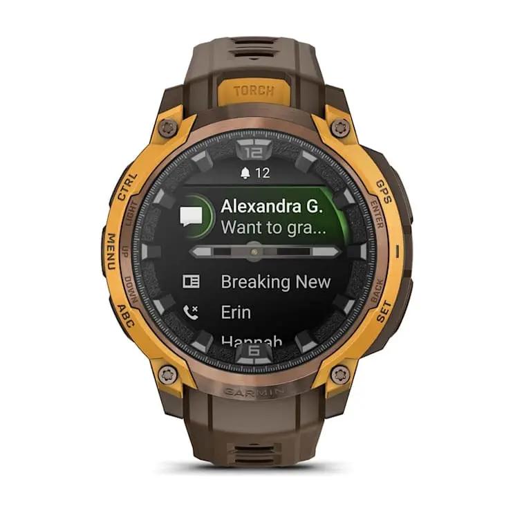 Garmin Instinct Crossover AMOLED smartwatch with orange bezel and brown strap.