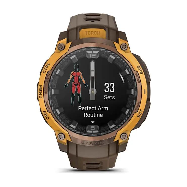Garmin Instinct Crossover AMOLED smartwatch with gold bezel and brown strap, showing workout screen.